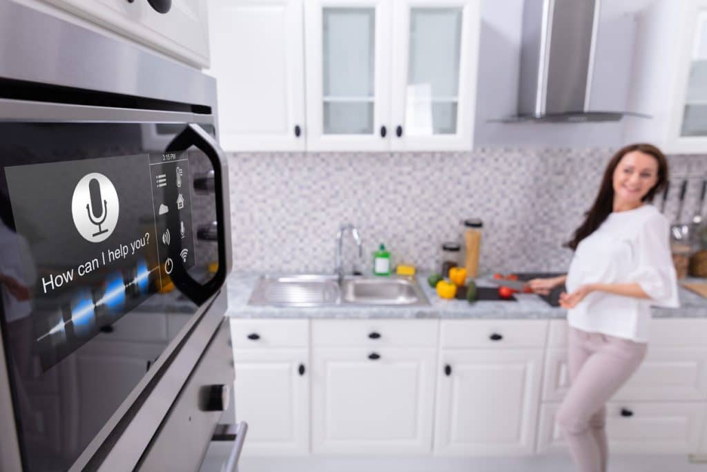 Close-up Of An Oven With Voice Recognition Function Near Woman Standing In Background